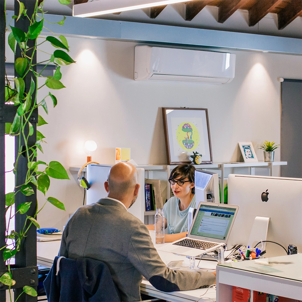 GLYNT_WP_7Questions_IntroPic Two coworkers speak across a work table