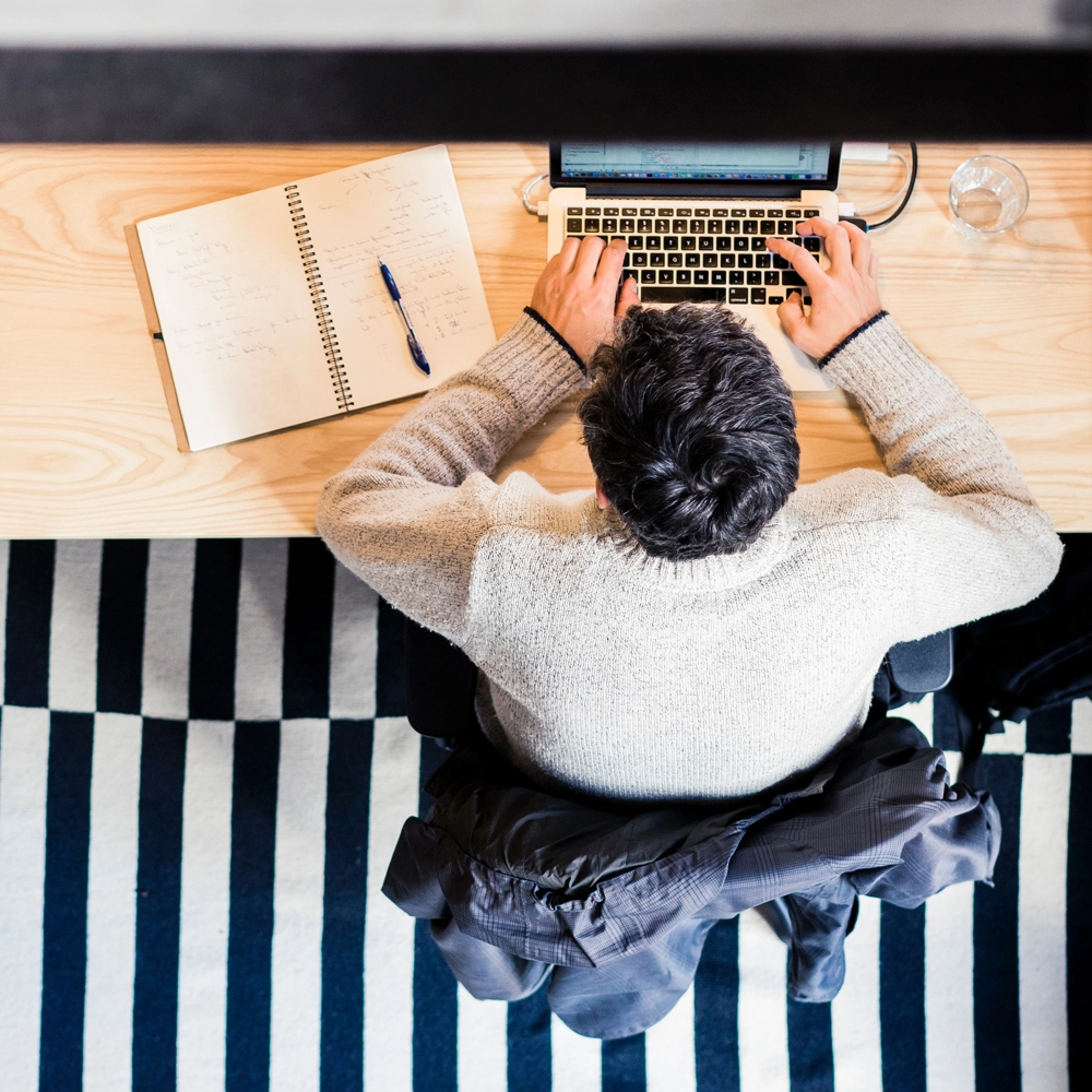 GLYNT_WP_7Questions_Pic2 A man, viewed from above, works on a laptop