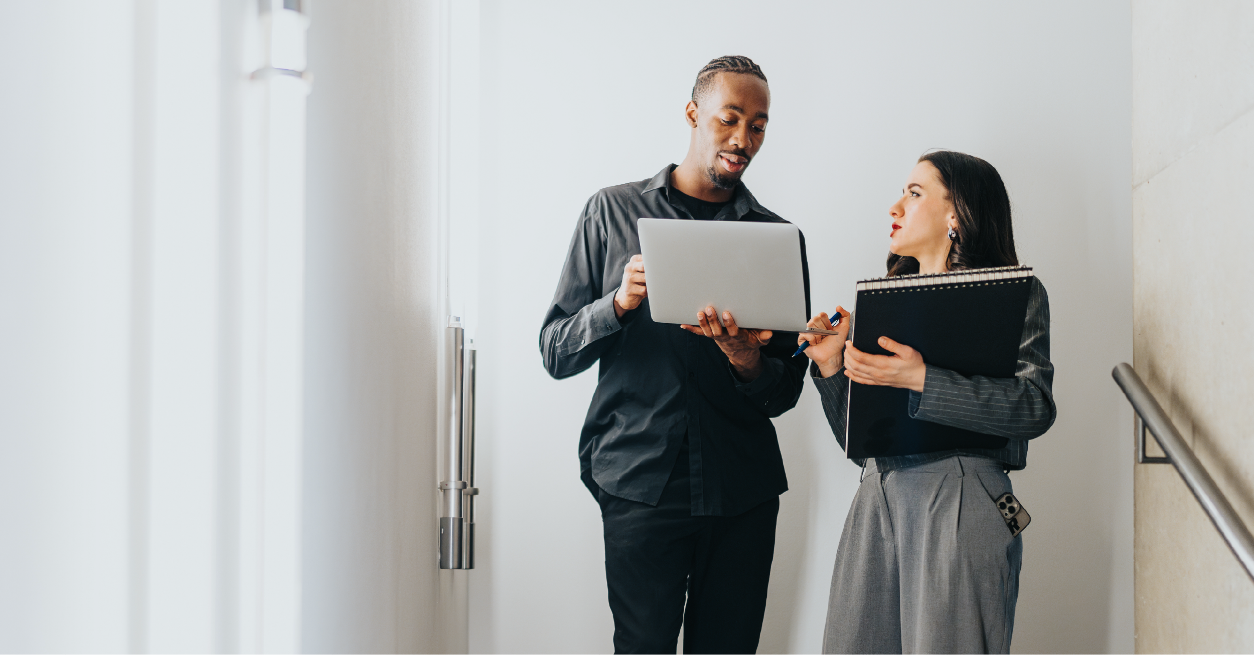 Two coworkers talking over an open laptop